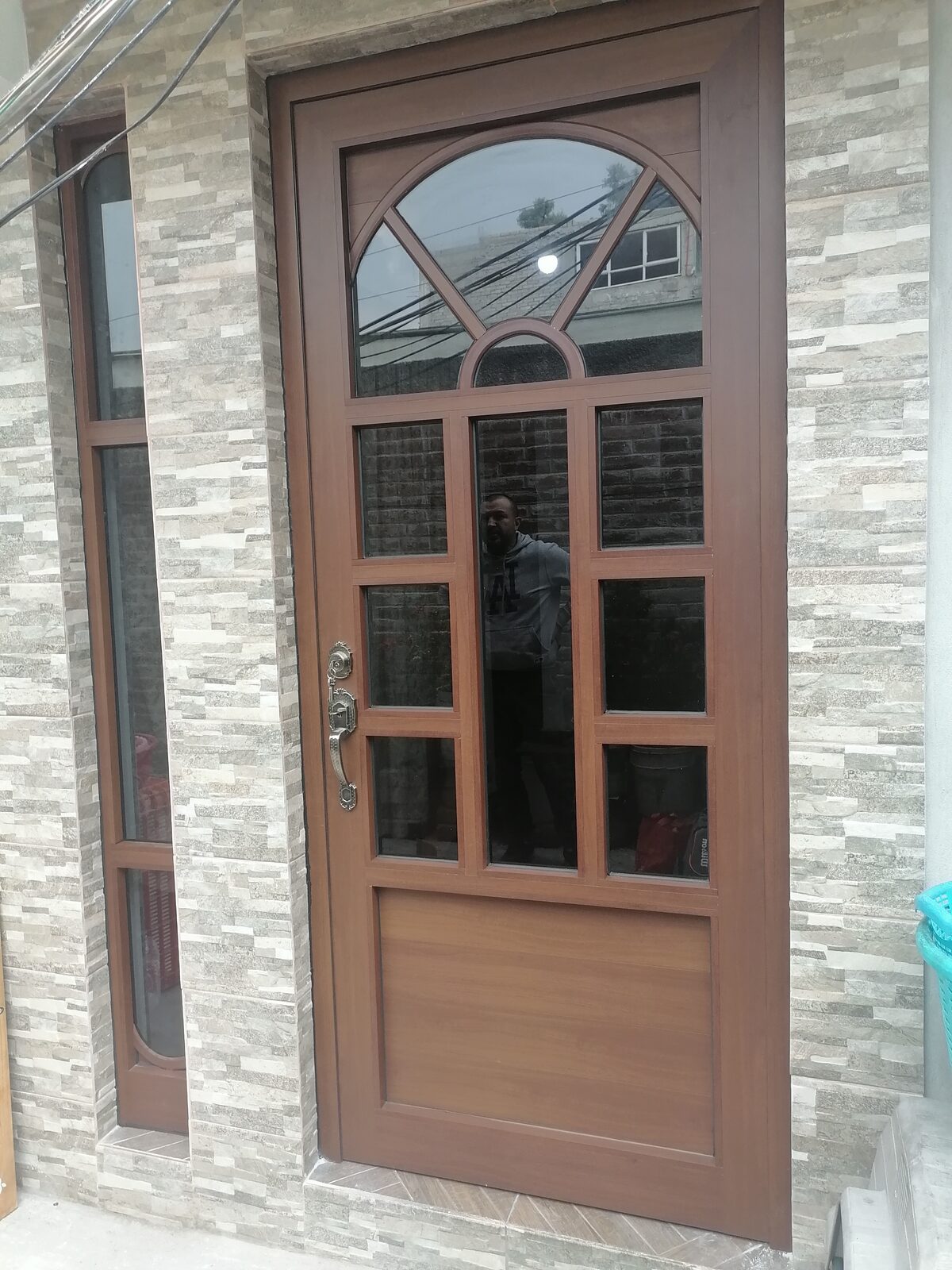 Puerta principal de aluminio acabado madera, vista frontal