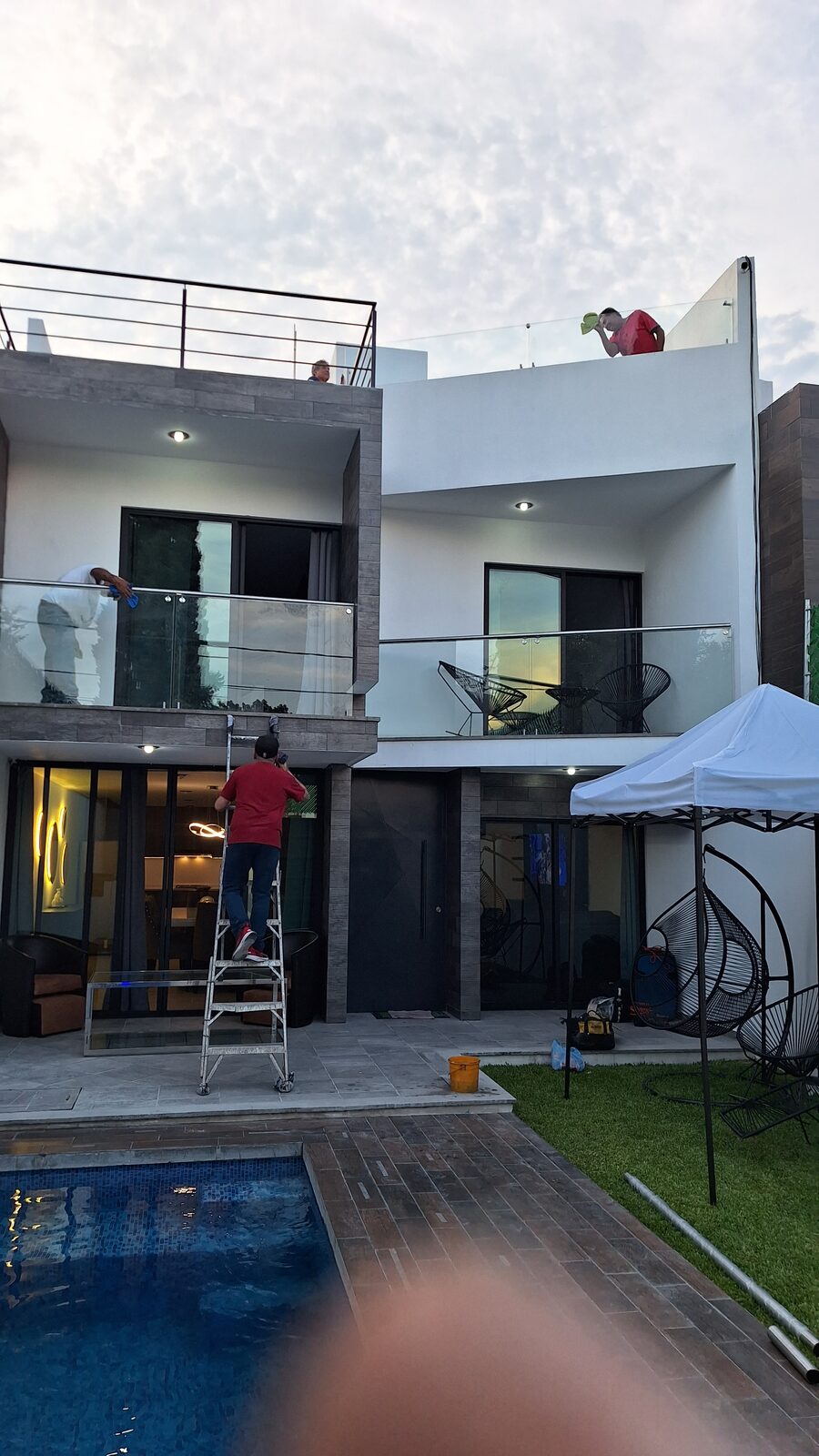 Fachada de casa con barandales de vidrio en dos niveles
